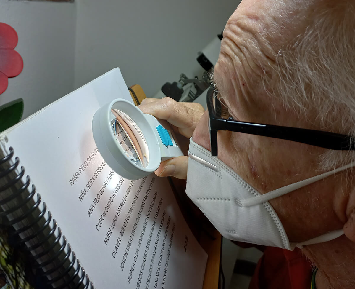 Adulto con baja visión usando ayudas visuales